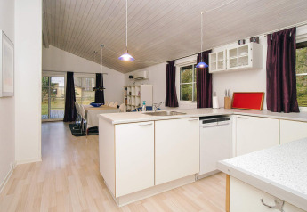 Lyst, moderne køkken og spisestue i et sommerhus til seks personer i Store Fuglede, Danmark.
