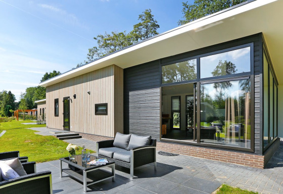 Moderne Lodge Grand Modern im Holiday Park De Lochemse Berg in den Niederlanden mit großer Terrasse.