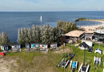 Luftaufnahme der Tiny Wagon Lodge in Marina Parcs Almere, Niederlande, mit Blick auf das Wasser.