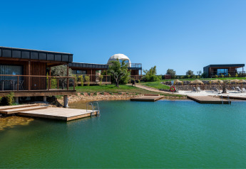 Vue sur le Dome House Duplex Do Lago au Wecamp Reserva Alecrim au Portugal avec lac, pontons et lodges modernes