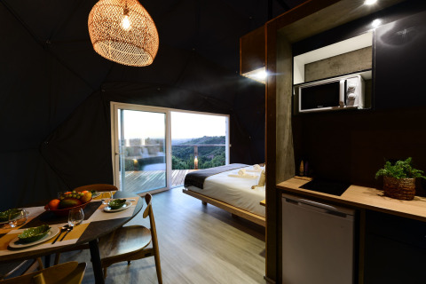Interieur van een familiedome met open keuken en eetruimte bij Wecamp Reserva Alecrim in Portugal.