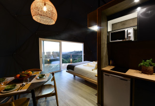 Interieur van een familiedome met open keuken en eetruimte bij Wecamp Reserva Alecrim in Portugal.