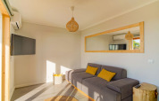 Lyst opholdsområde i Dome House på Wecamp Reserva Alecrim, Portugal, med grå sofa og spejl.