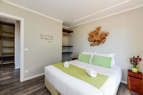 Moderne slaapkamer bij Dome House Duplex, Wecamp Reserva Alecrim, Portugal, met groene details en houten decoratie.