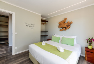 Moderne slaapkamer bij Dome House Duplex, Wecamp Reserva Alecrim, Portugal, met groene details en houten decoratie.