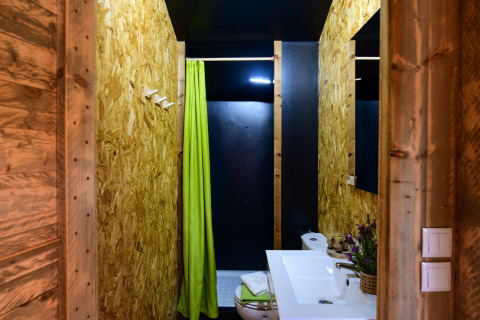 Badkamer in de Lodge Family safaritent bij Wecamp Reserva Alecrim, Portugal, met groene douchegordijn.