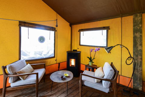 Interior de la tienda de safari Lodge Family en Wecamp Reserva Alecrim, Portugal, con decoración acogedora.
