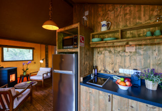 Interieur van de Lodge Family safaritent bij Wecamp Reserva Alecrim in Portugal met keuken en zithoek.