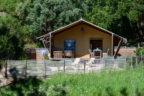 Lodge Family safaritent bij Wecamp Reserva Alecrim in Portugal, omringd door groen en houten afrastering.