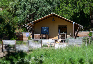 Safari Lodge Family tent bij Wecamp Reserva Alecrim in Portugal, omgeven door groene natuur en houten hek.