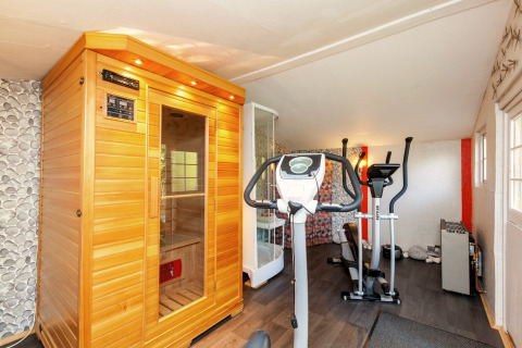 Sauna de madera, equipo de fitness y cabina de ducha en el mobil home Manureva en Bélgica.