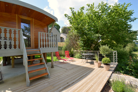 Terraza de madera con muebles de exterior y plantas en la casa móvil 'Manureva' en Bélgica.