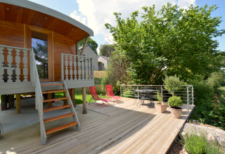 Terraza de madera con muebles de exterior y plantas en la casa móvil 'Manureva' en Bélgica.