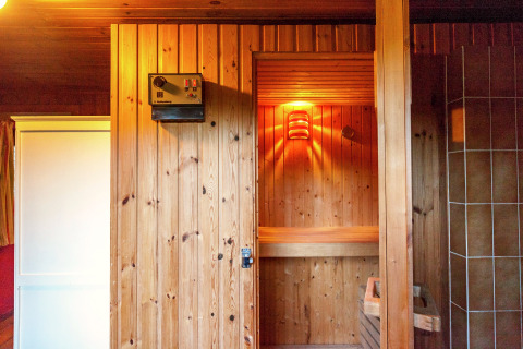 Vista interior de una sauna de madera en la casa móvil Manureva en Bélgica, iluminada para relajarse.