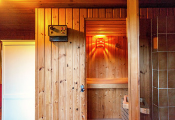 Vista interior de una sauna de madera en la casa móvil Manureva en Bélgica, iluminada para relajarse.