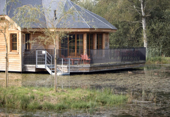 Casetta di legno chiamata 'Happiness' in Belgio con terrazza sull’acqua circondata dalla natura.