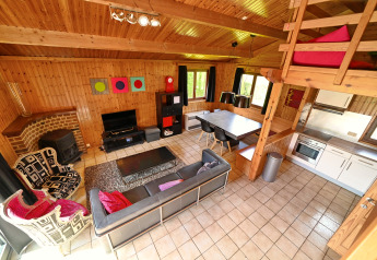 Gezellige leefruimte in Ard Zen lodge in België met moderne meubels, zithoek, eethoek en houten wanden.