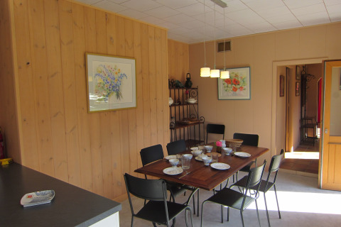 Eetkamer in de lodge Les Peupliers de la pecherie in België, tafel gedekt, houten wanden en veel daglicht.