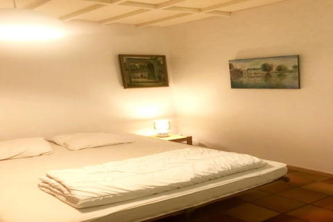 Slaapkamer in Les Peupliers de la Pecherie lodge in België met tweepersoonsbed, kussens en wanddecoratie.