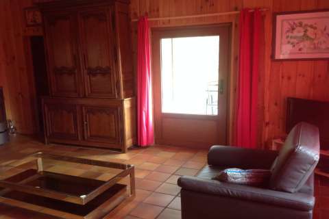 Gezellige woonkamer in Les Peupliers de la pecherie, België, met houten muren en comfortabele zetel.