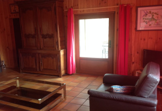 Gezellige woonkamer in Les Peupliers de la pecherie, België, met houten muren en comfortabele zetel.