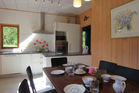 Gezellige keuken en eetruimte in Les Peupliers de la pecherie lodge in België, mooi gedekte tafel.