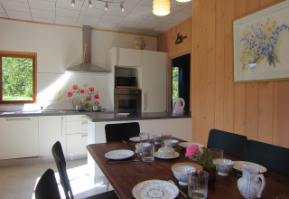 Gezellige keuken en eetruimte in Les Peupliers de la pecherie lodge in België, mooi gedekte tafel.