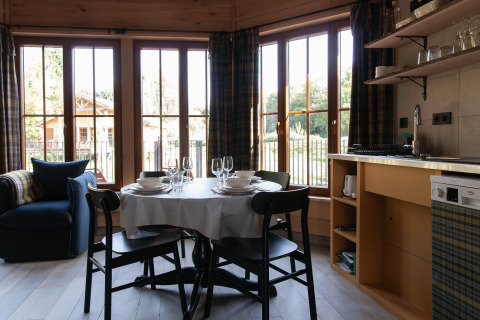 Bright kitchen and dining area at Cabane 'The Funny Friends' in Belgium, featuring large windows and cozy décor.