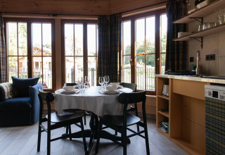 Bright kitchen and dining area at Cabane 'The Funny Friends' in Belgium, featuring large windows and cozy décor.