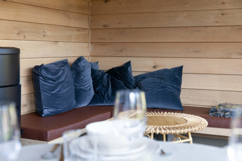 Cozy corner with blue pillows and wooden paneling at Cabane 'The Funny Friends' lodge in Belgium.