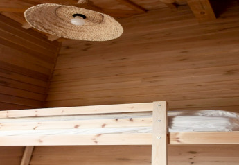 Letto a castello in legno e lampada intrecciata all’interno del lodge «Happiness» in Belgio.