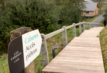 Segnale di accesso pedonale e passerella della lodge 'Happiness', Les Cabanes de Vencimont, Belgio.