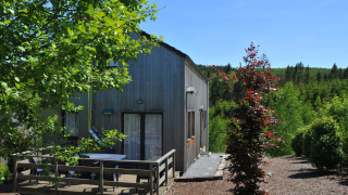 Houten lodge Les Jardins de l'Ourthe 8 met terras, midden in het groen en met zicht op omliggende bossen.