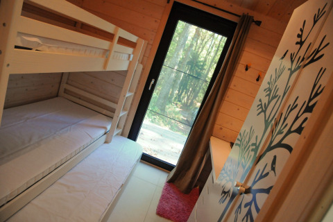 Kinderkamer met stapelbed en uitzicht op bos, chalet Drôles d'écureuil in België, moderne inrichting.