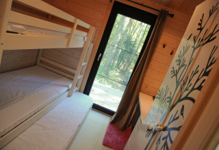 Kinderkamer met stapelbed en uitzicht op bos, chalet Drôles d'écureuil in België, moderne inrichting.