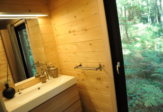 Moderne badkamer met houten wanden en boszicht vanuit chalet 'Drôles d'écureuil' in België.