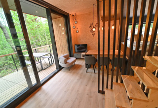Modern lodge room with wooden decor, open terrace, and forest view at Village de Vacances Oignies 5 in Belgium.