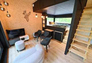 Modern lodge interior at Village de Vacances Oignies 5 in Belgium with bedroom loft and cozy living area.