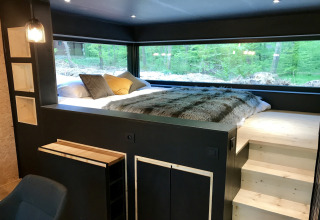 Modern bedroom with large windows offering forest views at Village de Vacances Oignies 5 in Belgium.