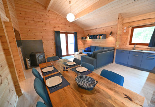 Interno dello chalet 'Village de Vacances Oignies 6' in Belgio con pareti in legno e arredamento blu.