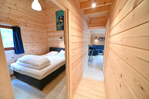 Camera da letto e corridoio in legno nel chalet 'Village de Vacances Oignies 6' in Belgio, atmosfera accogliente.