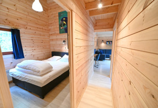 Camera da letto e corridoio in legno nel chalet 'Village de Vacances Oignies 6' in Belgio, atmosfera accogliente.