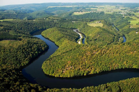 Luftfoto af floden Ourthe, der snor sig gennem frodige, grønne skove tæt ved Les Jardins de l'Ourthe 8 i Belgien.