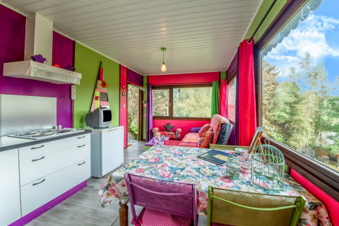 Colorful yurt interior at La Pause Insolite in Belgium featuring bright decor and large windows with nature views.