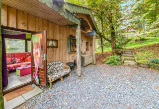 Charming wooden yurt at La Pause Insolite in Belgium, surrounded by greenery and colorful interior decor.