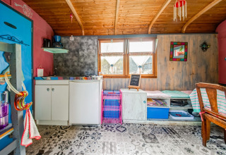 Colorful interior of mobile home Les Roulottes de Vio in Belgium, featuring a compact kitchen and seating area.
