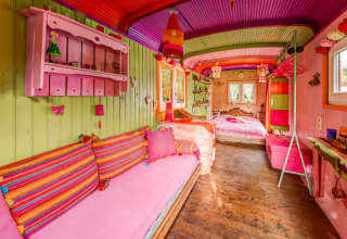 Colorful mobile home interior at 'Les Roulottes de Vio' in Belgium, featuring bright decor and wooden walls.