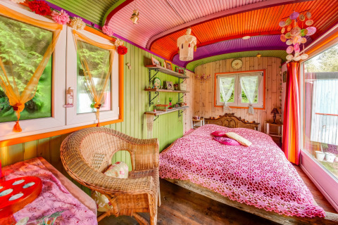 Colorful bedroom in the mobile home Les Roulottes de Vio in Belgium, featuring cozy and creative decor.