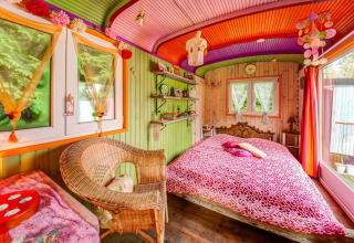 Colorful bedroom in the mobile home Les Roulottes de Vio in Belgium, featuring cozy and creative decor.