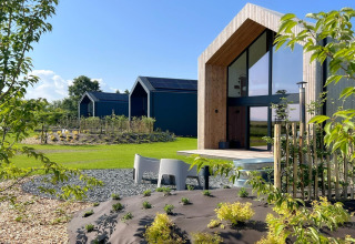 Moderne hytte kaldet 'Natural Escape' i Belgien, med store vinduer, trædetaljer og grøn have